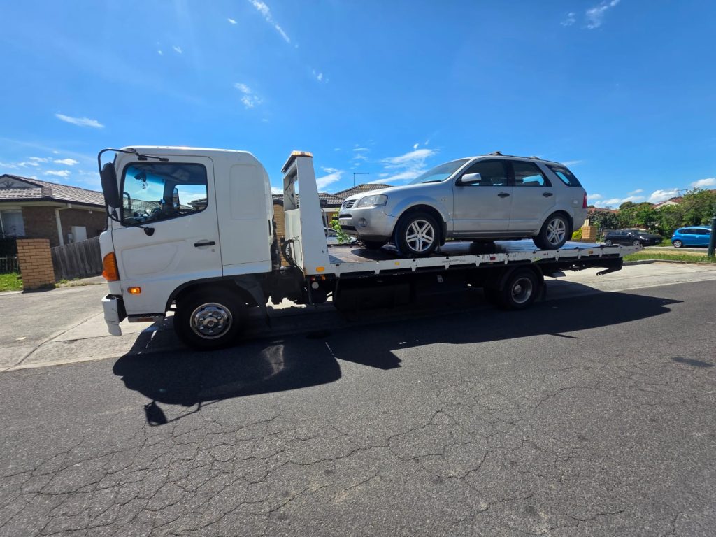 Cash for Scrap Cars Dandenong VIC 1 Silver SUV loaded on a white flatbed tow truck on a residential street