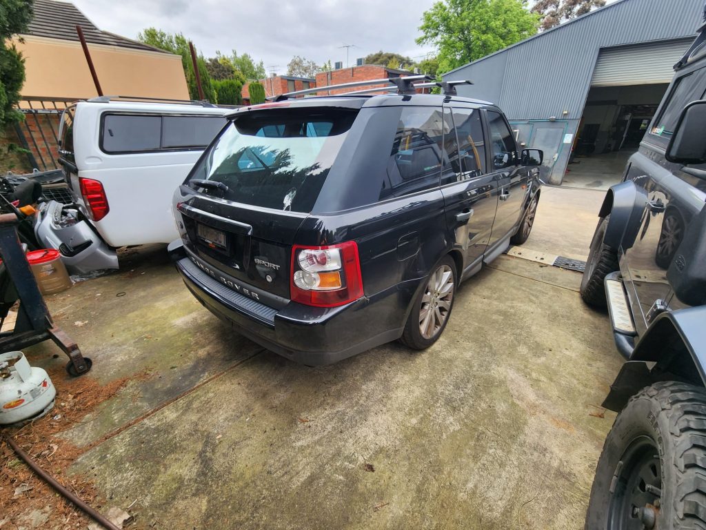 Cash for Scrap Cars Brighton VIC 1 Dark Range Rover parked beside vans and other four-wheel-drives in a yard