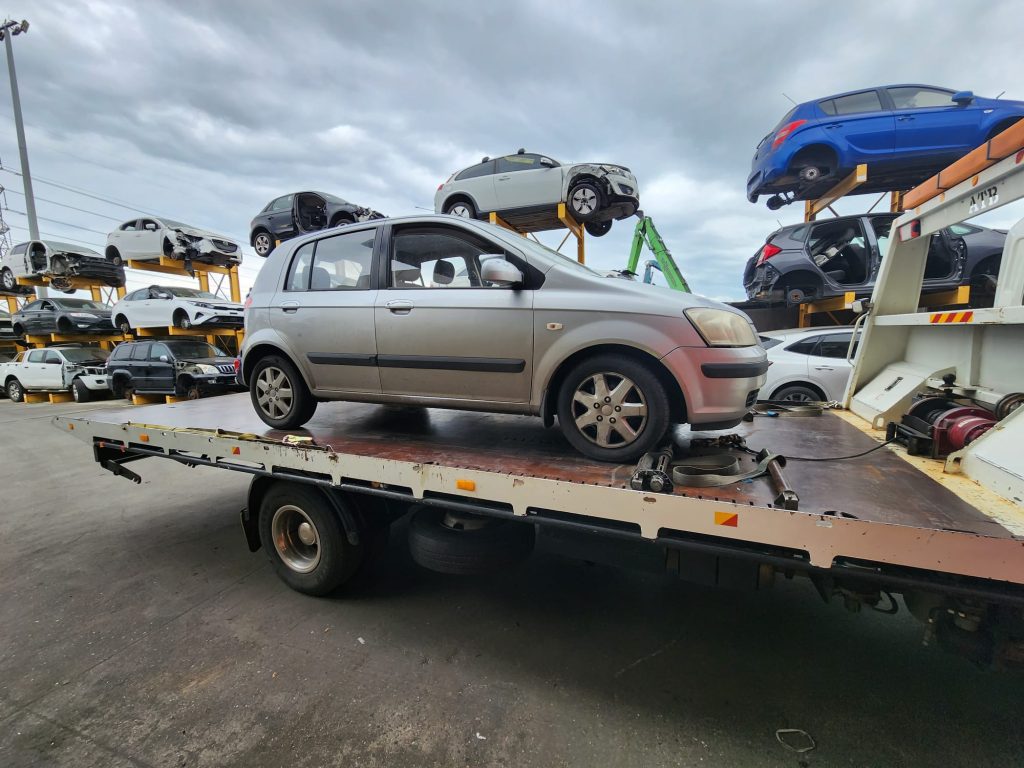 Cash for Scrap Cars Dewhurst VIC 1 Silver hatchback on a tow truck with vehicle storage racks behind it