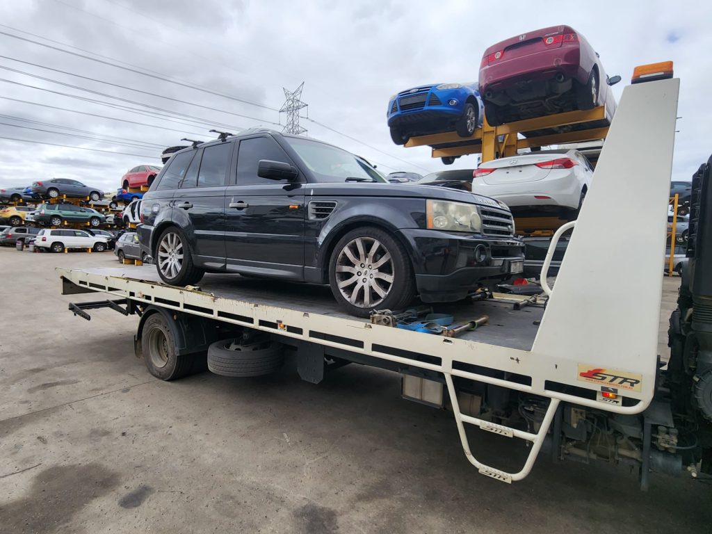 Cash for Scrap Cars Hallam VIC 1 Dark SUV loaded on a white tow truck in a vehicle recycling yard
