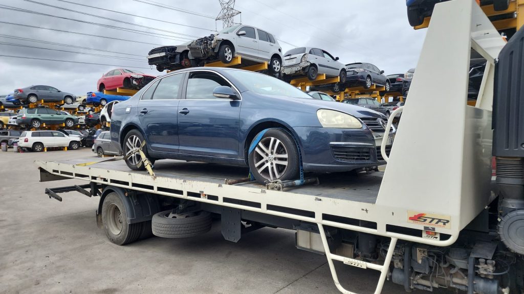 Cash for Scrap Cars Carrum Downs VIC 1 Blue sedan secured on a flatbed tow truck in a vehicle yard