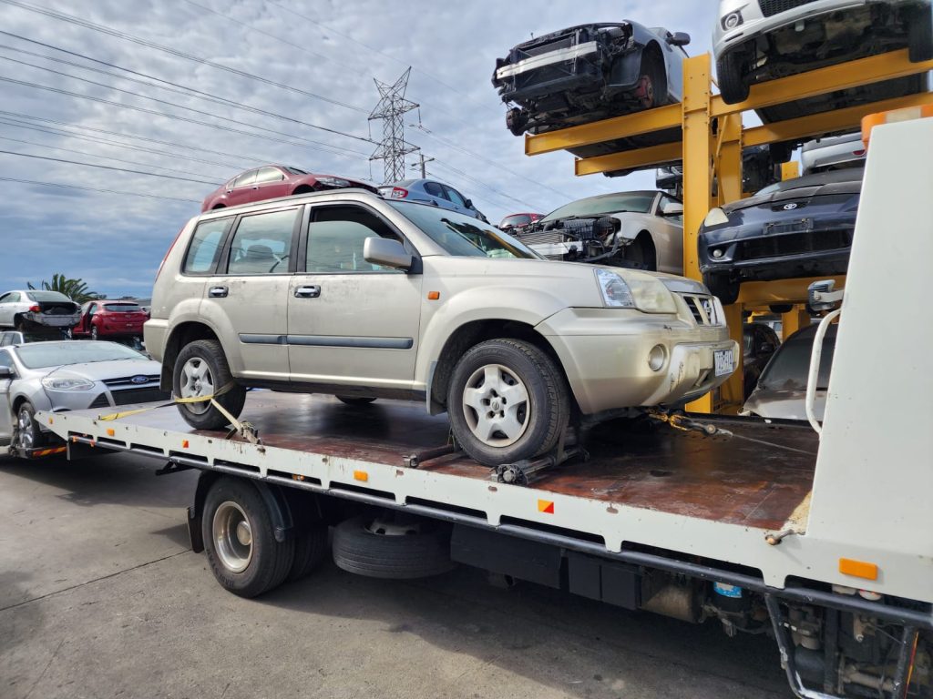 Cash for Scrap Cars Mordialloc VIC 1 Silver SUV secured to a tow truck among stacked vehicles