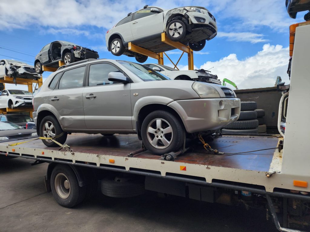 Cash for Scrap Cars Shoreham VIC 1 Silver SUV on a flatbed truck beside a recycling yard