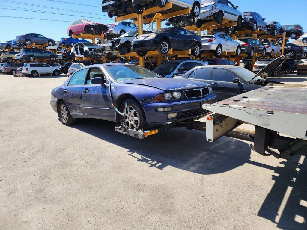 Cash for Scrap Cars Werribee VIC 1 Dark convertible beside a tow truck ramp